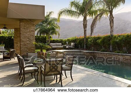 Outdoor table by swimming pool View Large Photo Image Picture - Outdoor table by swimming pool. Fotosearch
