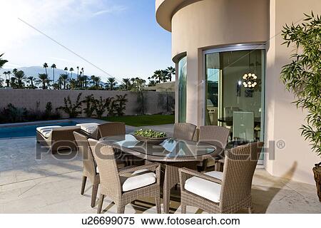 Stock Photography - Outdoor table on patio by swimming pool. Fotosearch