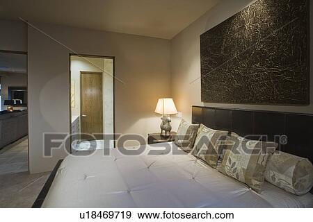Palm Springs bedroom with lit bedside lamp View Large Photo Image Stock Photo - Palm Springs bedroom with lit bedside lamp. Fotosearch