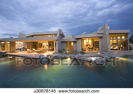 Stock Photography - Palm Springs swimming pool and house exterior at dusk. Fotosearch