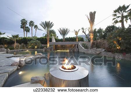 Stock Image - Palm Springs swimming pool with live flame heater. Fotosearch