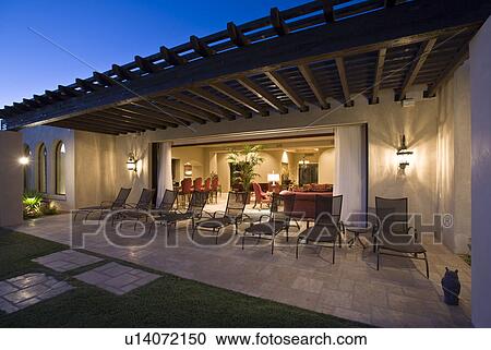 Stock Image - Patio with deckchairs outside modern building dusk. Fotosearch