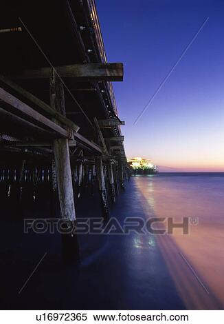 Pier illuminated at sunset View Large Photo Image Stock Photography - Pier illuminated at sunset. Fotosearch