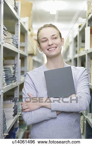 Portrait of a woman holding a book View Large Photo Image Stock Photograph - Portrait of a woman holding a book. Fotosearch