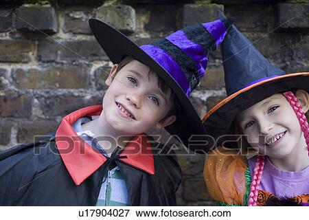 Stock Photo - Portrait of girl and boy wearing witches hats. Fotosearch