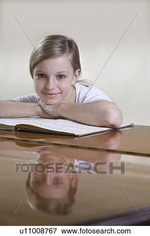 Stock Photo - Portrait of teenage girl (13-15) at piano. Fotosearch