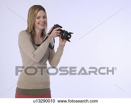 Portrait of young (20-25 years) female photographer holding camera studio shot View Large Photo Image Stock Image - Portrait of young (20-25 years) female photographer holding camera studio shot. Fotosearch