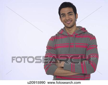 Stock Image - Portrait of young (20-25 years) man smiling studio shot. Fotosearch
