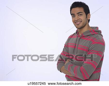 Stock Photography - Portrait of young (20-25 years) man smiling studio shot. Fotosearch