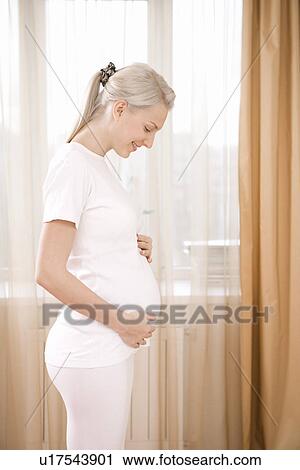 Pregnant woman by window View Large Photo Image Stock Image - Pregnant woman by window. Fotosearch