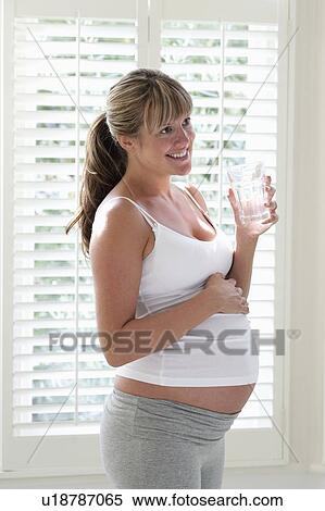 Stock Photography - Pregnant woman holding glass of water. Fotosearch