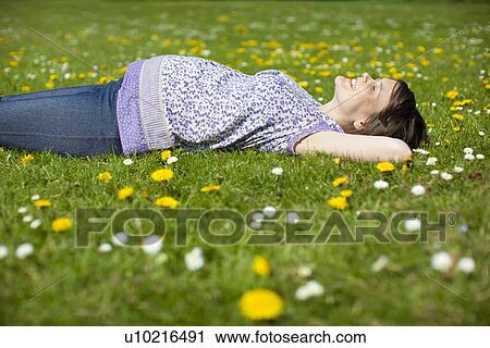 Pregnant woman lying on grass View Large Photo Image Stock Image - Pregnant woman lying on grass. Fotosearch