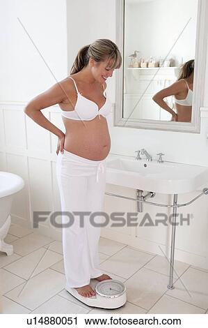 Pregnant woman standing on bathroom scales View Large Photo Image Stock Image - Pregnant woman standing on bathroom scales. Fotosearch