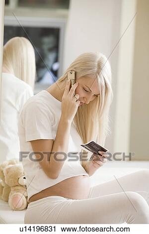 Pregnant woman using mobile phone on bed View Large Photo Image Stock Image - Pregnant woman using mobile phone on bed. Fotosearch