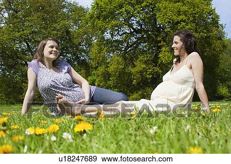 Pregnant women sitting on grass View Large Photo Image Stock Photo - Pregnant women sitting on grass. Fotosearch