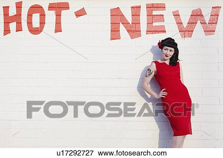 Retro woman in red dress posing against a brick wall View Large Photo Image Stock Photo - Retro woman in red dress posing against a brick wall. Fotosearch