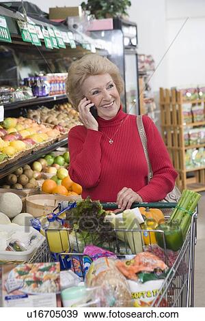Stock Photo - Senior woman grocery shopping. Fotosearch