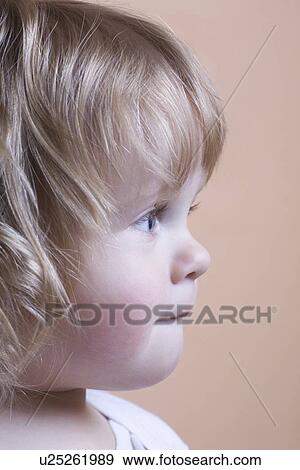 Stock Photo - Side view profile of blonde toddler with baby curls. Fotosearch