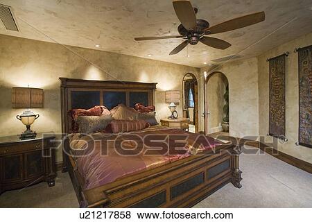 Stock Photo - Silk bedcover on antique bed in Palm Springs home. Fotosearch