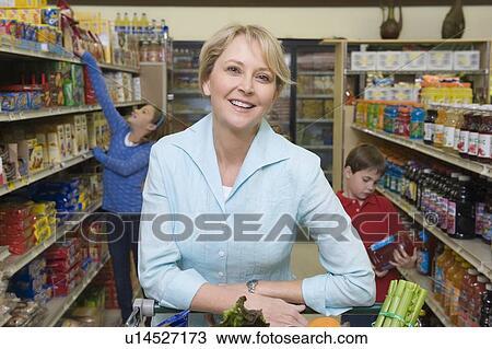 Stock Image - Single mother shopping with son and daughter. Fotosearch