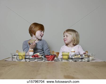 Sisters sit eating breakfast together and talking View Large Photo Image Picture - Sisters sit eating breakfast together and talking. Fotosearch