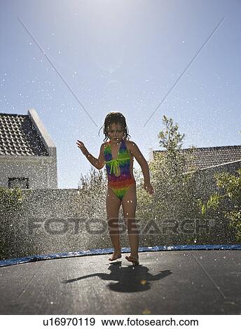 Stock Photo - South Africa Cape Town girl jumping on trampoline. Fotosearch