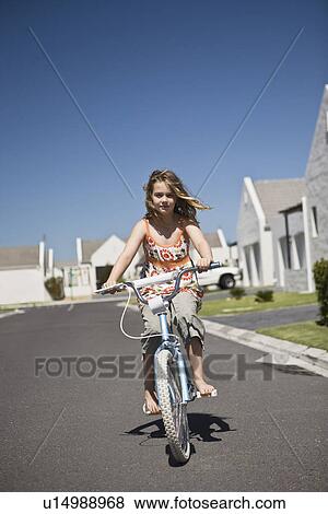 Stock Photo - South Africa Cape Town girl riding bicycle on street. Fotosearch