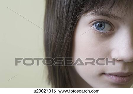 Stock Photography - Studio portrait of girl with brown hair smiling. Fotosearch