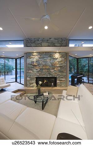 Stock Image - Sunken seating area and exposed stone fireplace of Palm Springs home. Fotosearch