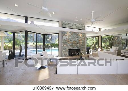 Stock Photo - Sunken seating area and exposed stone fireplace of Palm Springs home. Fotosearch