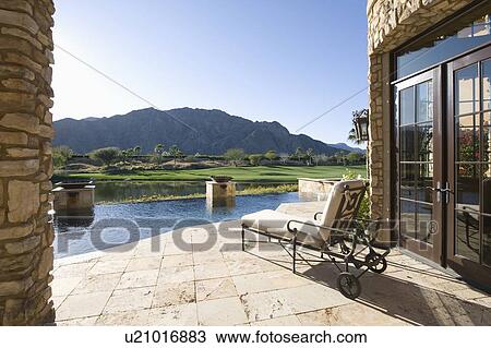 Stock Image - Sunlounger with view of mountains in Palm Springs Riverside County California. Fotosearch