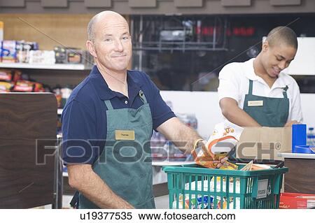 Stock Photography - Supermarket employee and check out assistant. Fotosearch