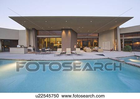 Stock Image - Swimming pool and paved seating area of Palm Springs home exterior. Fotosearch