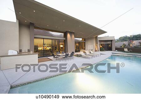 Swimming pool and paved seating area of Palm Springs home exterior View Large Photo Image Stock Photo - Swimming pool and paved seating area of Palm Springs home exterior. Fotosearch