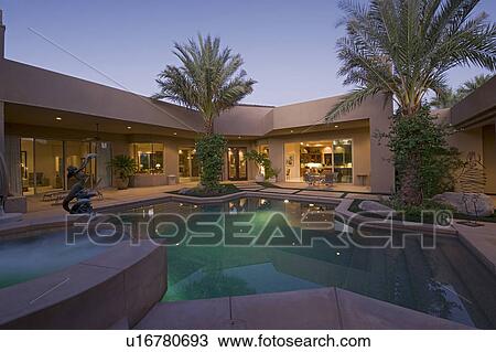 Stock Image - Swimming pool in back yard of modern residence. Fotosearch