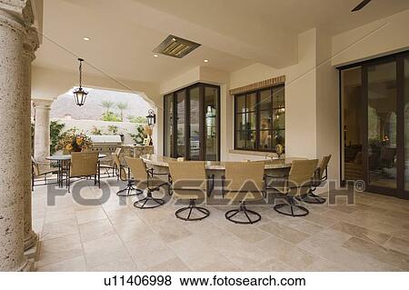 Stock Photo - Swivel armchairs at bar area of outdoor room Palm Springs home. Fotosearch