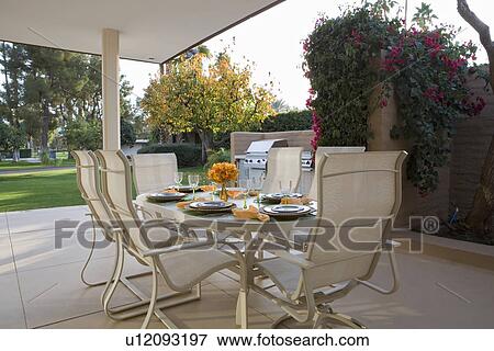 Stock Photo - Table set for meal on patio. Fotosearch