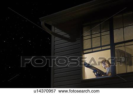 Teenage boy with telescope at open window looking at night sky View Large Photo Image Stock Photo - Teenage boy with telescope at open window looking at night sky. Fotosearch