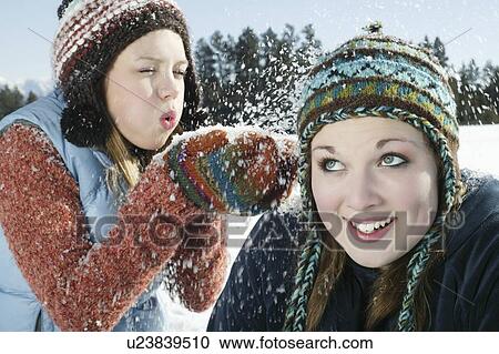 Teenage girl blows snow on her friend View Large Photo Image Stock Image - Teenage girl blows snow on her friend. Fotosearch