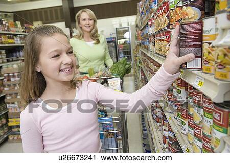 Teenage girl choosing products from supermarket shelf View Large Photo Image Stock Image - Teenage girl choosing products from supermarket shelf. Fotosearch