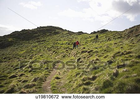 Three adults climbing a hillside View Large Photo Image Stock Image - Three adults climbing a hillside. Fotosearch