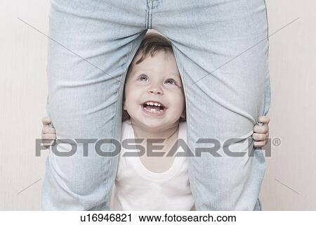 Toddler holds onto mothers legs looking up View Large Photo Image Stock Image - Toddler holds onto mothers legs looking up. Fotosearch