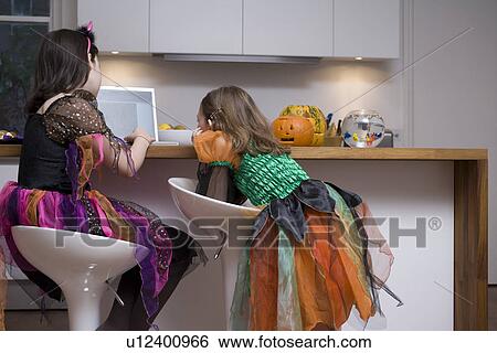 Stock Photograph - Two girls using laptop in home. Fotosearch