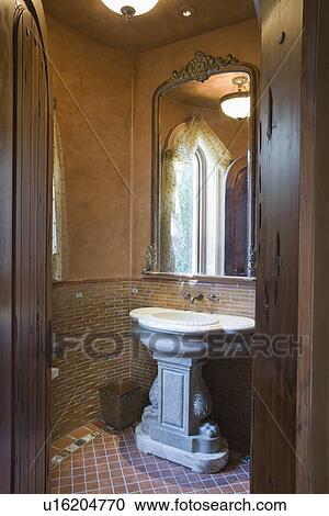 Stock Image - View through wooden doorway to stone wash stand. Fotosearch