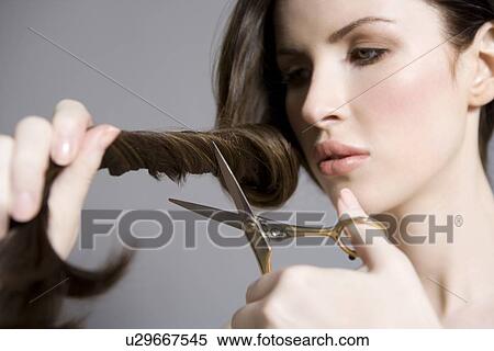 Woman cutting long brown hair View Large Photo Image Stock Photography - Woman cutting long brown hair. Fotosearch