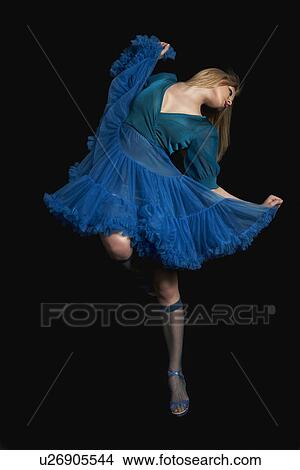 Picture - Woman dancing against black background. Fotosearch