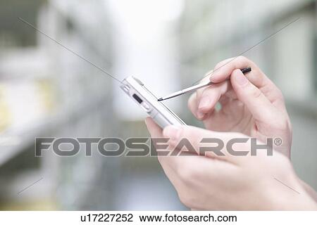 Woman holds palm pilot in library View Large Photo Image Stock Image - Woman holds palm pilot in library. Fotosearch