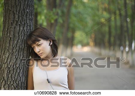 Woman listens to personal stereo in public park View Large Photo Image Stock Photo - Woman listens to personal stereo in public park. Fotosearch