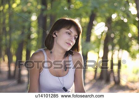 Woman listens to personal stereo in public park View Large Photo Image Stock Photography - Woman listens to personal stereo in public park. Fotosearch