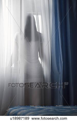 Woman looking through window back view View Large Photo Image Stock Photo - Woman looking through window back view. Fotosearch